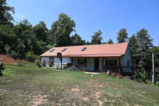 rear view of house featuring a lawn and covered porch