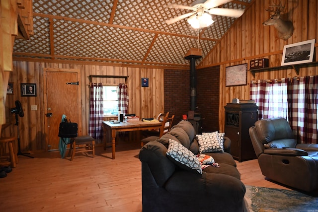 living room featuring hardwood / wood-style floors, a wood stove, and wooden walls