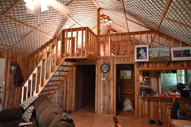 unfurnished living room featuring ceiling fan, high vaulted ceiling, and hardwood / wood-style floors