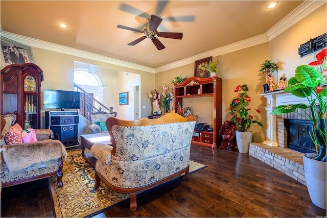 living room featuring a fireplace, ceiling fan, crown molding, and wood-type flooring