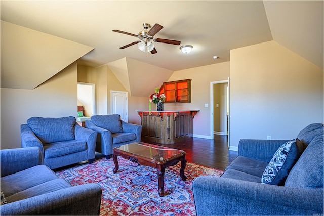 living room featuring ceiling fan, vaulted ceiling, dark wood-type flooring, and indoor bar