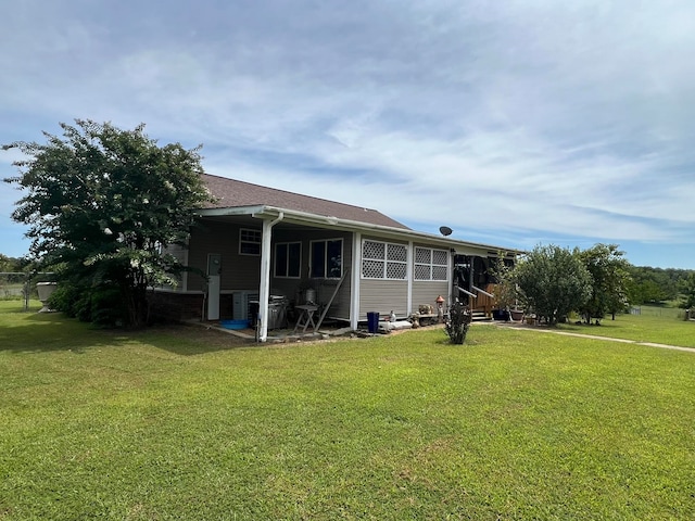 rear view of house featuring a yard