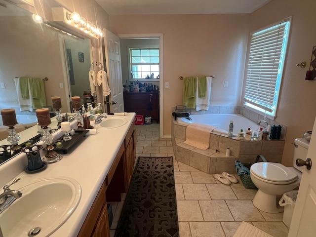 bathroom featuring tile patterned floors, vanity, tiled bath, and toilet