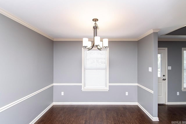 empty room featuring crown molding, dark hardwood / wood-style flooring, and a chandelier