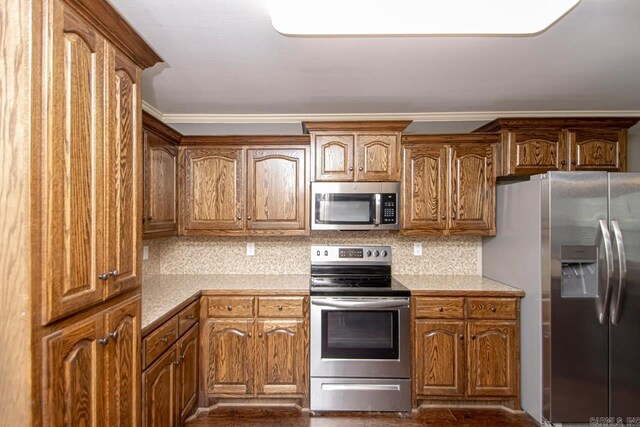 kitchen featuring tasteful backsplash, ornamental molding, and stainless steel appliances