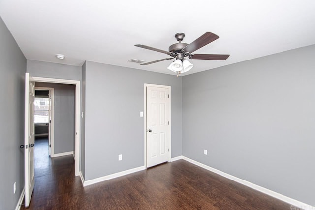 unfurnished room with ceiling fan and dark hardwood / wood-style flooring