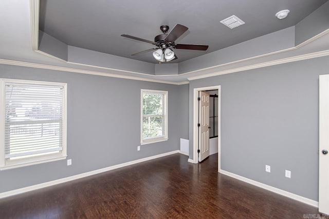 unfurnished room featuring ceiling fan, crown molding, a tray ceiling, and dark wood-type flooring