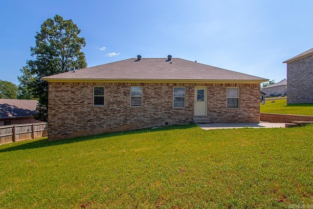 rear view of house with a patio area and a lawn