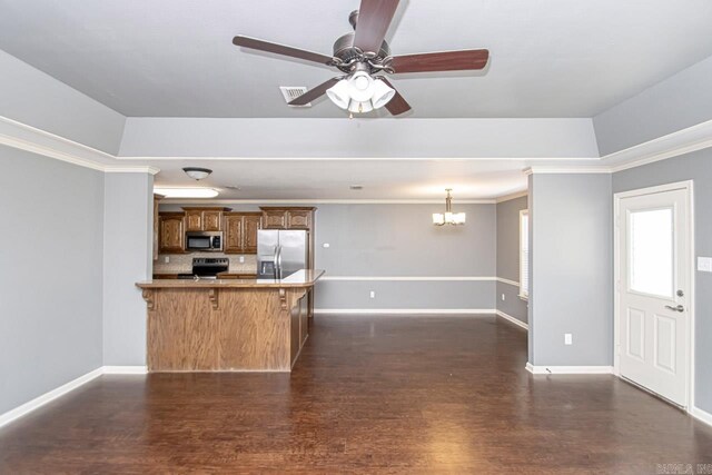 kitchen with a kitchen bar, dark hardwood / wood-style floors, and stainless steel appliances