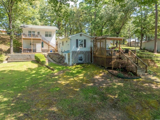 back of house with a wooden deck and a lawn