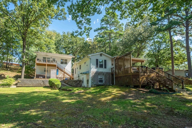 rear view of property with a wooden deck and a lawn