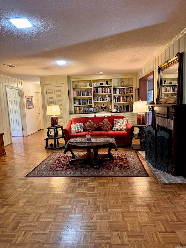 living room with a textured ceiling, built in features, and parquet floors