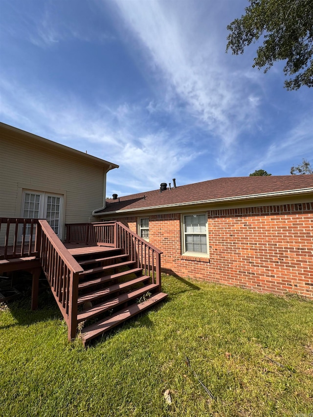 rear view of house featuring a yard and a wooden deck