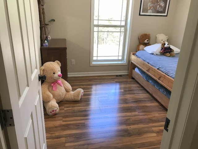 bedroom with dark hardwood / wood-style flooring