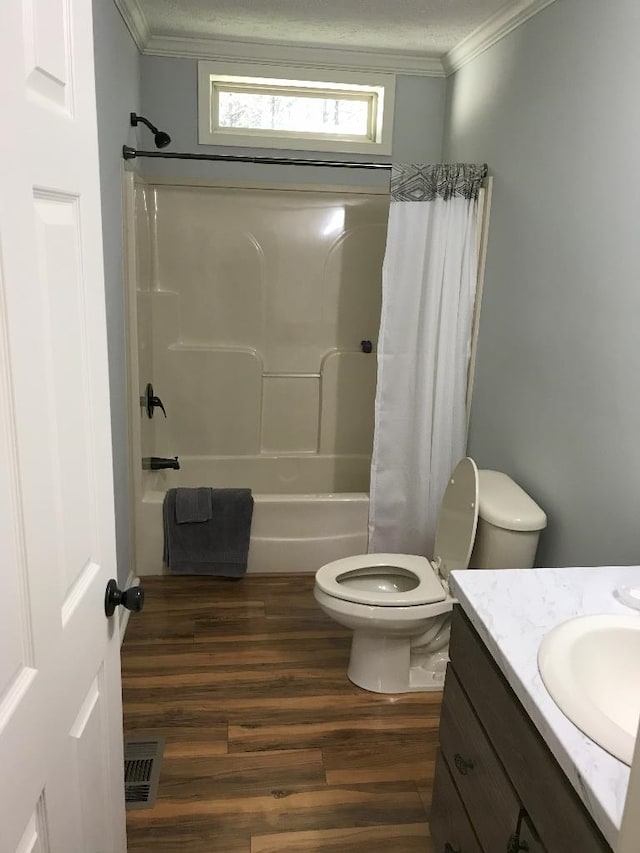 full bathroom featuring hardwood / wood-style flooring, toilet, shower / bath combination with curtain, vanity, and crown molding