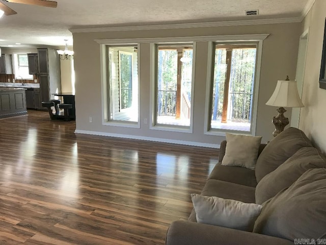 living room featuring dark hardwood / wood-style floors, sink, ceiling fan with notable chandelier, and ornamental molding