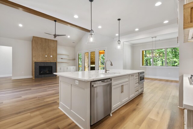 kitchen with a wealth of natural light, light wood-type flooring, stainless steel dishwasher, and white cabinetry