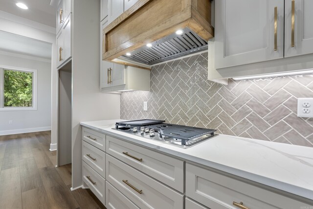 kitchen featuring backsplash, ornamental molding, white cabinets, dark hardwood / wood-style flooring, and custom exhaust hood