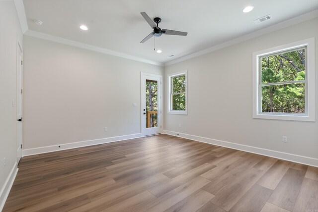 empty room featuring ceiling fan, light hardwood / wood-style floors, a healthy amount of sunlight, and ornamental molding