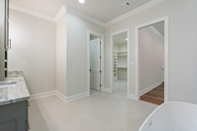 bathroom featuring a tub, crown molding, vanity, and wood-type flooring