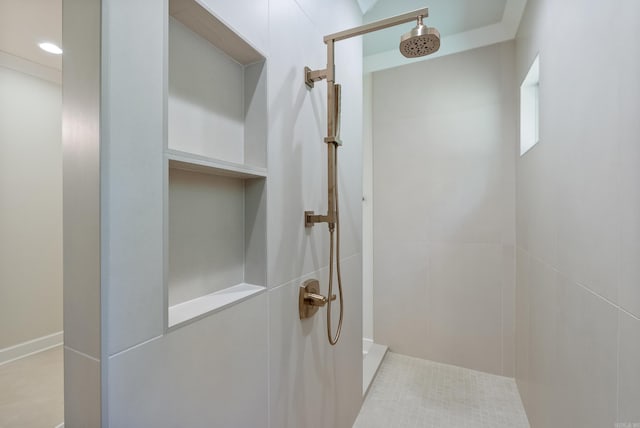 bathroom with a tile shower and tile patterned floors