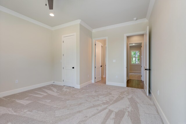 unfurnished bedroom featuring ceiling fan, ornamental molding, and carpet flooring