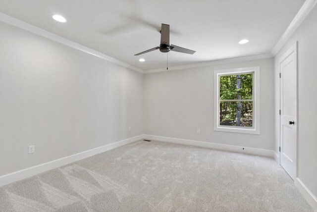 empty room featuring ceiling fan, ornamental molding, and carpet