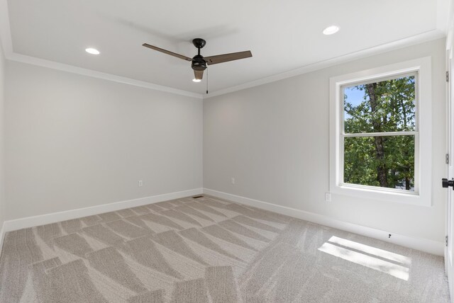 carpeted empty room featuring ceiling fan and crown molding