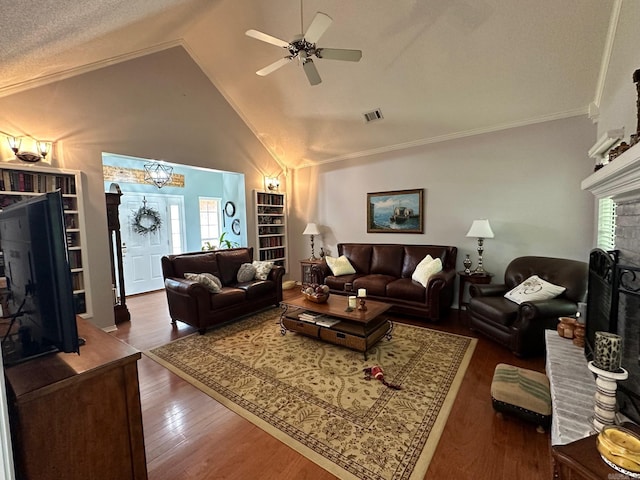 living room with ornamental molding, dark hardwood / wood-style floors, vaulted ceiling, a textured ceiling, and ceiling fan