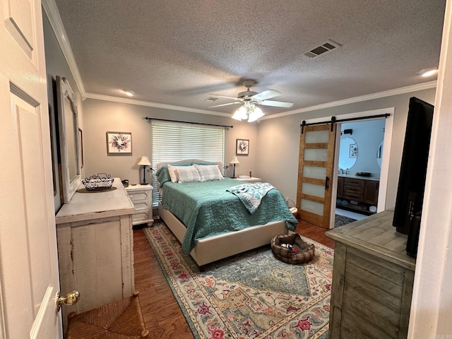 bedroom featuring dark hardwood / wood-style floors, a textured ceiling, ceiling fan, a barn door, and crown molding