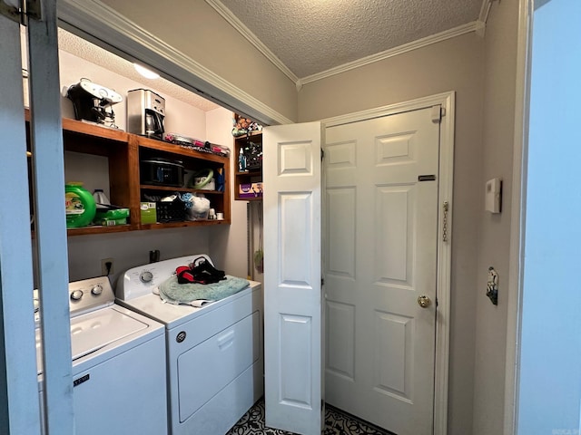 clothes washing area featuring washer and clothes dryer, a textured ceiling, and ornamental molding