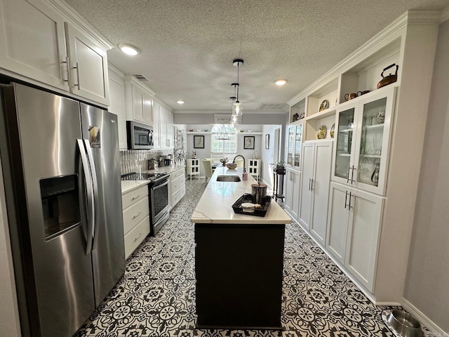 kitchen with backsplash, hanging light fixtures, white cabinetry, appliances with stainless steel finishes, and dark tile patterned floors