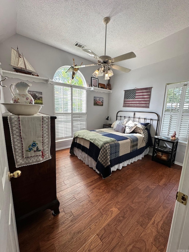 bedroom featuring ceiling fan, lofted ceiling, wood-type flooring, and multiple windows