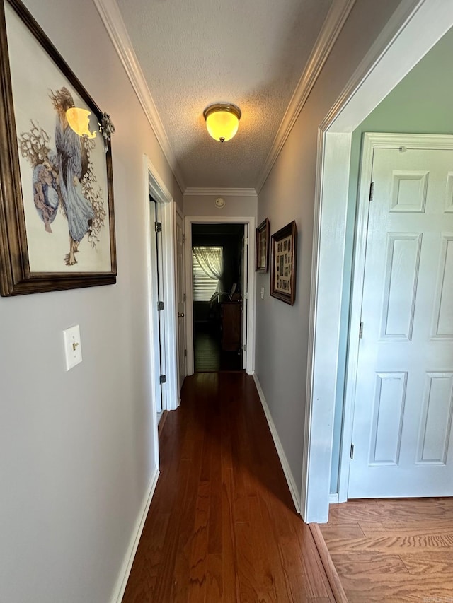 hall featuring hardwood / wood-style flooring, a textured ceiling, and crown molding