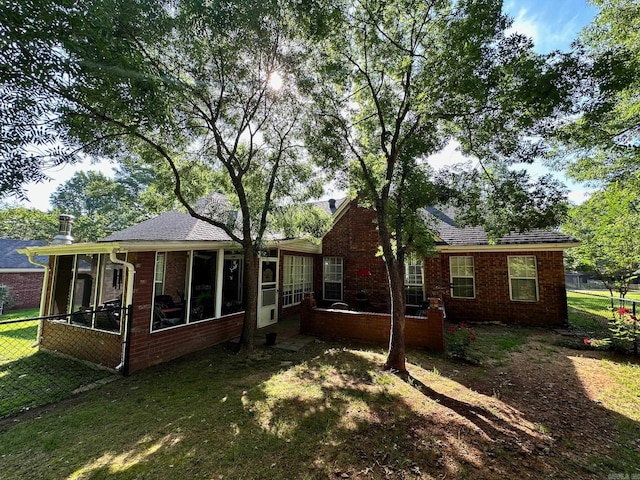 back of property featuring a yard and a sunroom