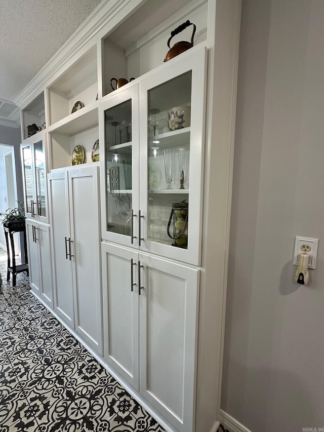 bar with crown molding, a textured ceiling, and tile patterned floors