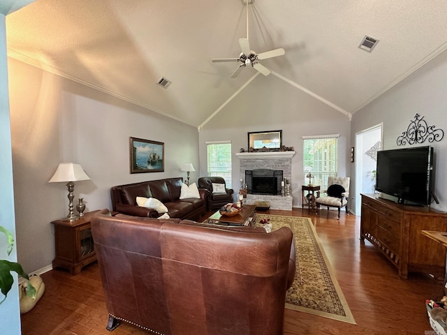 living room featuring a textured ceiling, high vaulted ceiling, dark hardwood / wood-style flooring, ceiling fan, and a stone fireplace