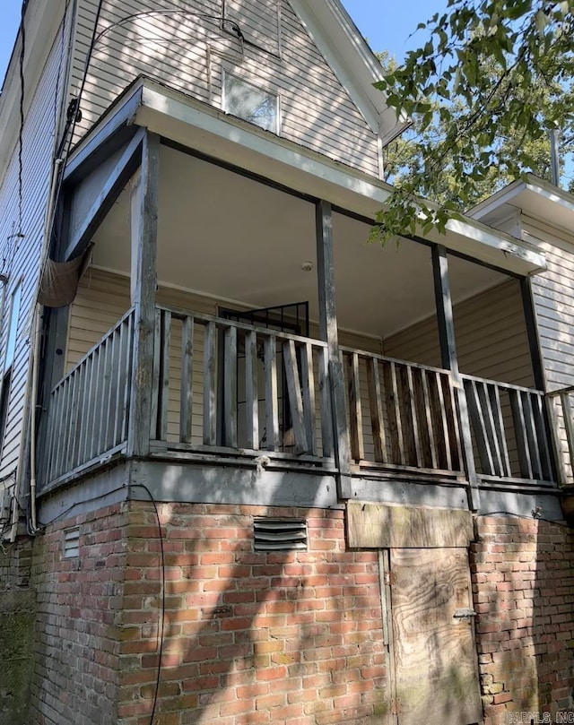 view of home's exterior with brick siding and a balcony