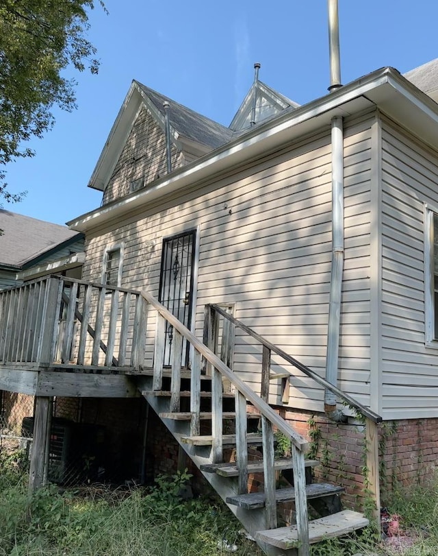 back of property featuring a deck and stairs