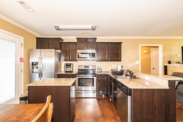 kitchen with appliances with stainless steel finishes, sink, dark brown cabinetry, and light stone counters