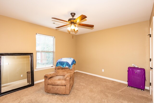 sitting room with ceiling fan and light carpet