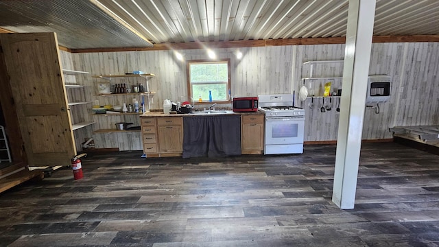 kitchen featuring dark wood-type flooring, a sink, heating unit, light brown cabinetry, and gas range gas stove