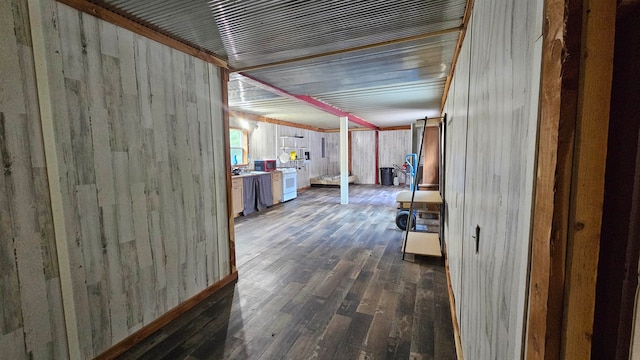 hall with wooden walls and dark wood-type flooring