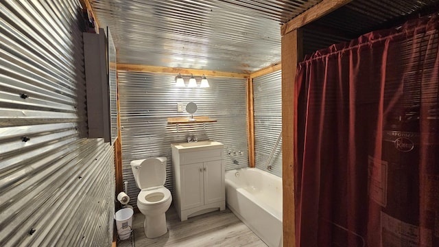 bathroom with vanity, wood finished floors, a garden tub, and toilet