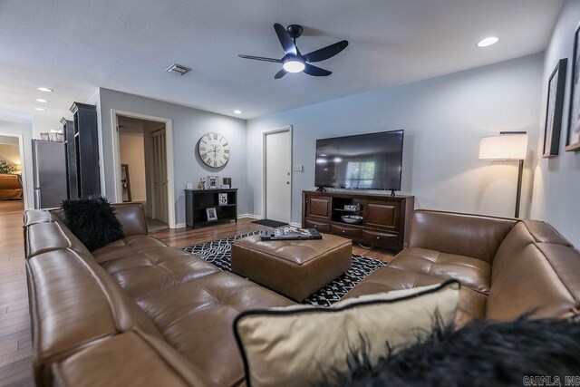 living room featuring ceiling fan and hardwood / wood-style floors