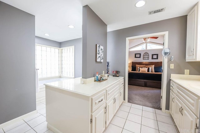 kitchen with kitchen peninsula, white cabinetry, and light tile patterned floors