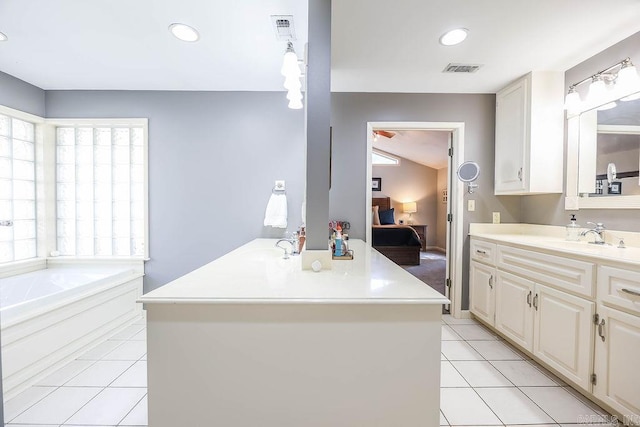 interior space featuring sink, white cabinetry, light tile patterned flooring, and a kitchen island