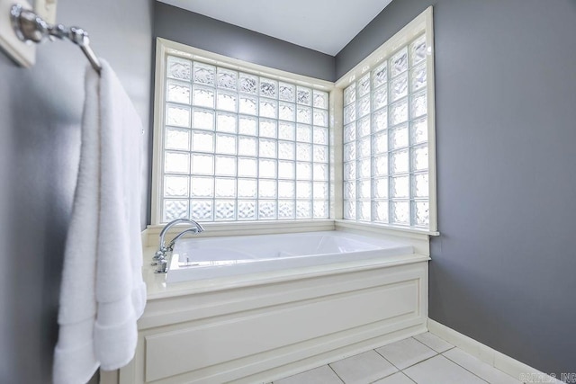 bathroom with tile patterned flooring and a bath