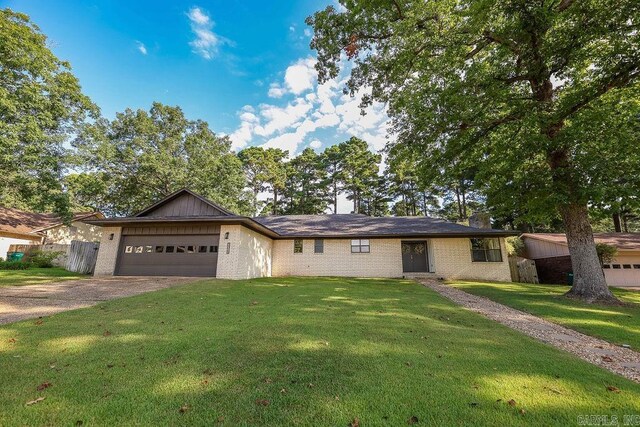 single story home with a garage and a front lawn