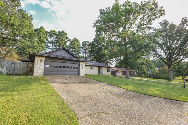 ranch-style home featuring a garage and a front lawn